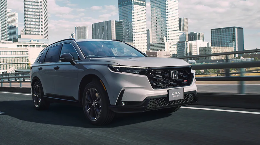 灰色のCR-V（6代目）を斜め前から見た外観。高層ビルが並ぶ街の道路を走っている