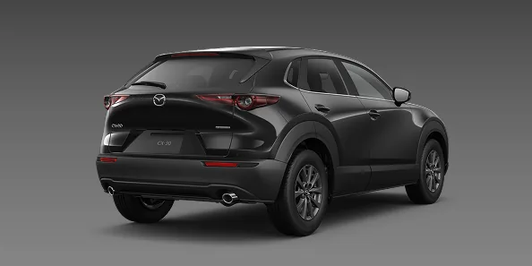灰色の背景に置いた黒いCX-30を右斜め後ろから見た外観。黒いボディに横長の赤いテールランプが分かる