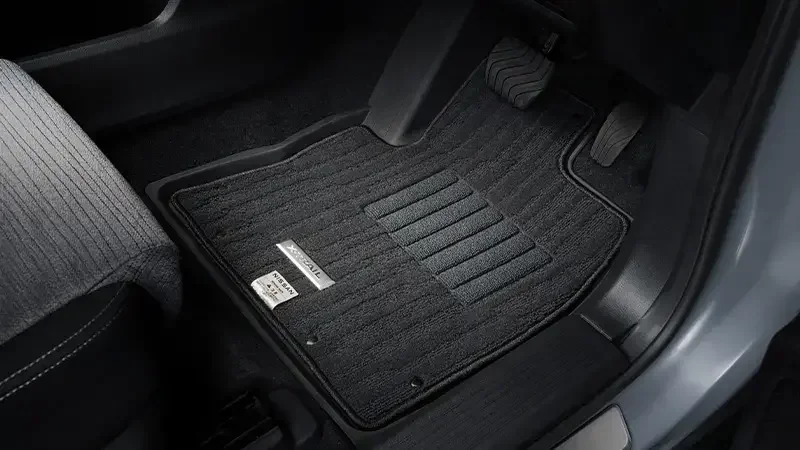 エクストレイルのフロアマット。運転席の足元に敷いた黒いカーペットに X-TRAIL のプレートが付いている