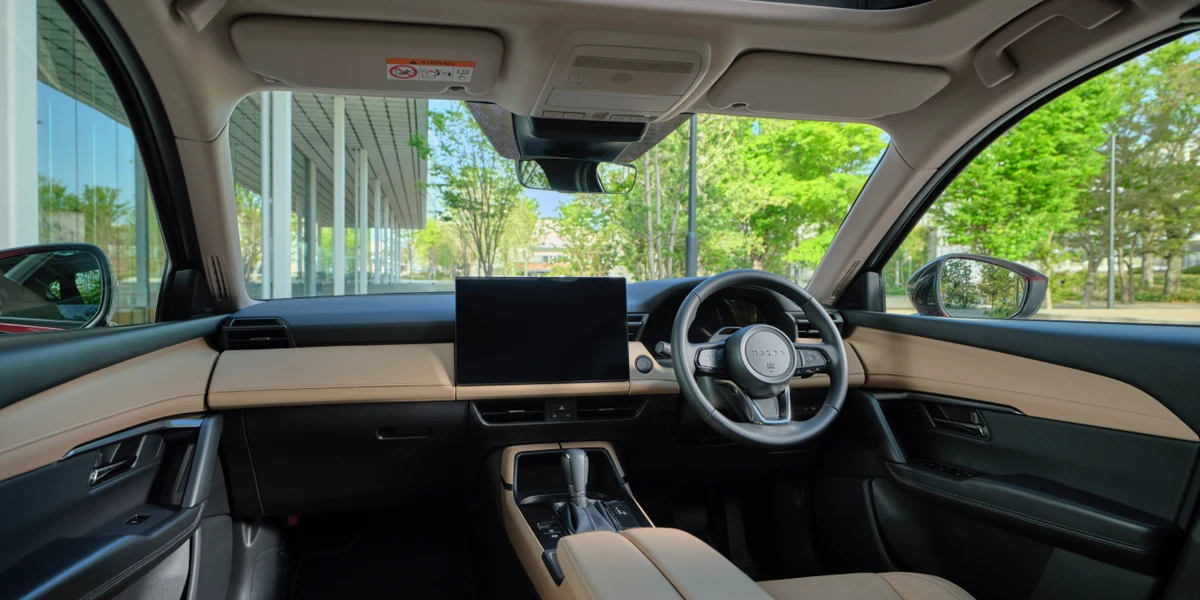 新型CX-5の運転席まわりを助手席側から見た内装。ベージュ色のダッシュボードの中央に、大きなディスプレイが立つ