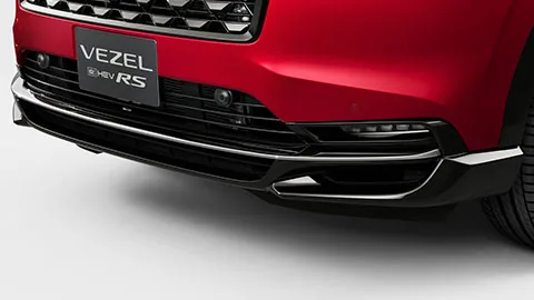 ヴェゼルe:HEV RSのフロントバンパー下部を寄りで写した写真。ダーククロームの細いモールディングと「VEZEL e:HEV RS」の表示が見える（公式の外観写真）