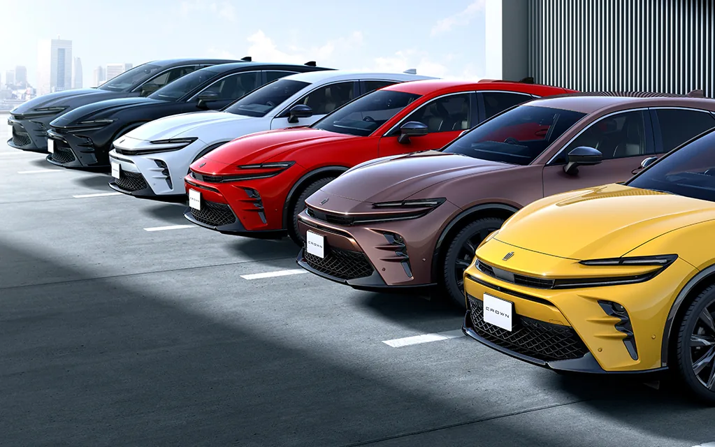 黒・白・赤・茶・黄など、ボディカラーの違うクラウン スポーツ6台が駐車場に斜めに並んだ外観の写真