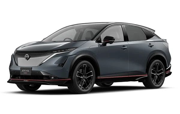 日産アリア NISMOの外観を左前から見た写真。濃い灰色のボディに、フロントバンパー下とサイドの下端に赤い線が入る