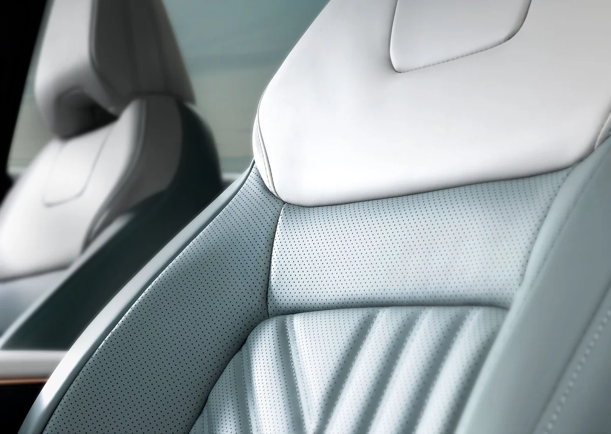 日産アリアの前席シートの接写。白い肩口と、淡い青緑の革の背もたれに縦のステッチが入る