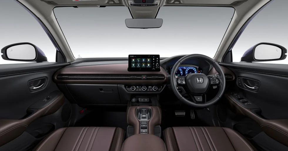 茶色の内装のZR-Vの運転席まわり。右ハンドルの前にメーター、中央にディスプレー、手前に茶色の前席2つが並ぶ