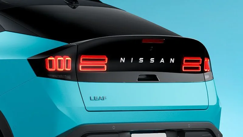 日産リーフの後ろ姿の接写。黒い帯の中に赤く光る四角いリアランプとNISSANの文字が並び、その下に「LEAF」のエンブレムが付く
