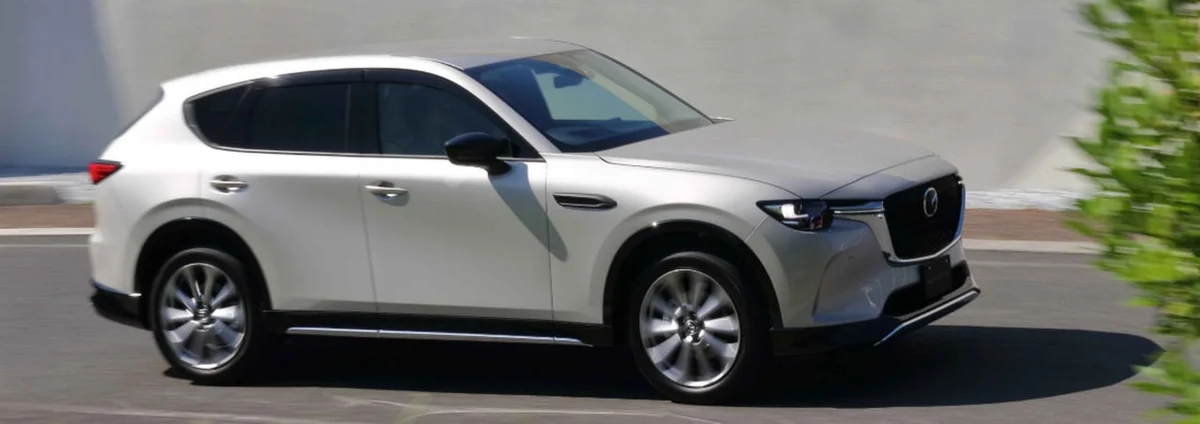 白いCX-60の斜め前から見た側面。黒いグリルと、道を走る様子が見える