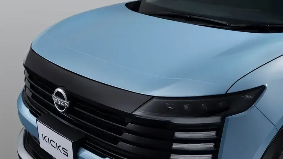 水色のキックスのボンネットとフロントグリルを斜めから見たところ。黒いグリルと日産のエンブレムが見える