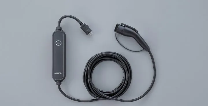 日産の公式サイトに載るリーフ用の充電ケーブル。コンセント側のプラグと車につなぐコネクターの間に、日産のマークの付いた黒い箱がある