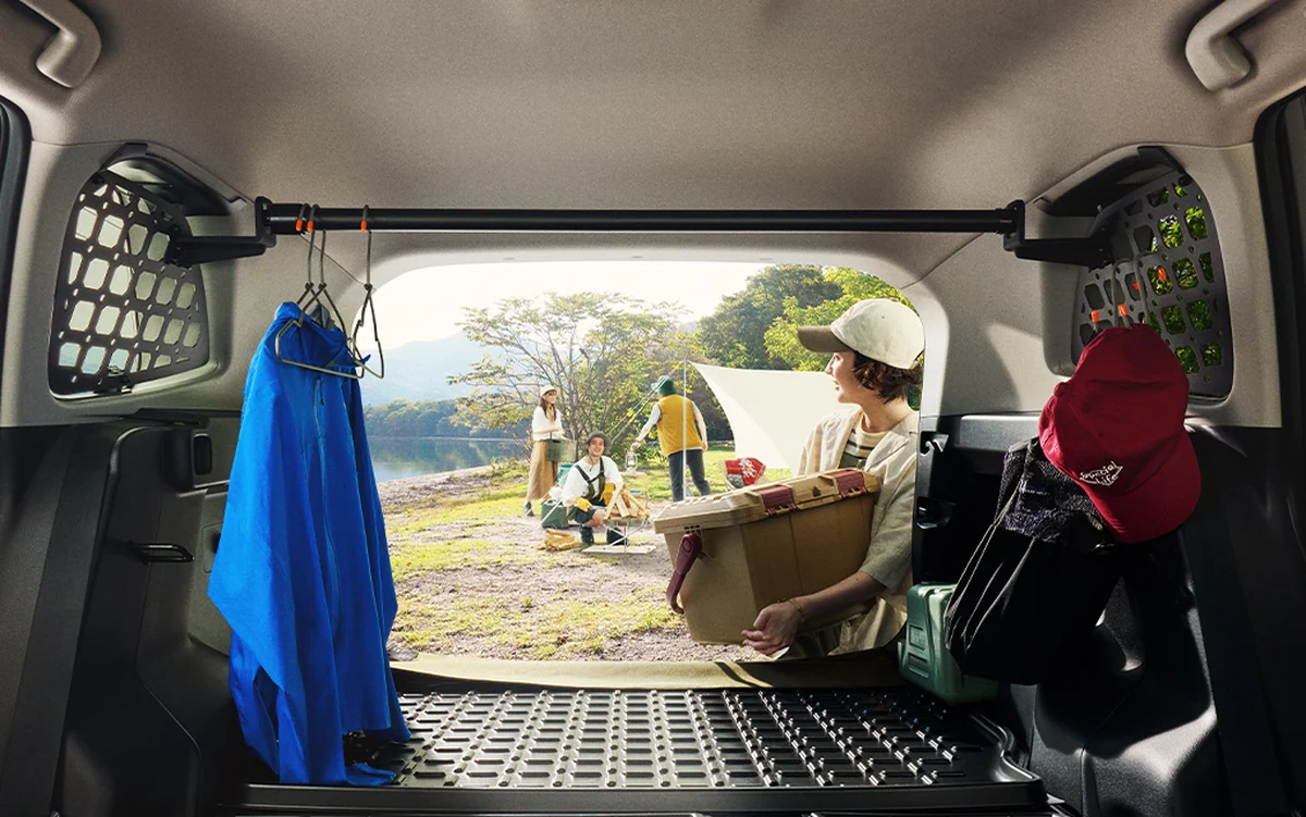 新型RAV4の荷室をリアゲート側から見た様子。側面のメッシュ状のパネルと、開口部の向こうのキャンプ場が見える