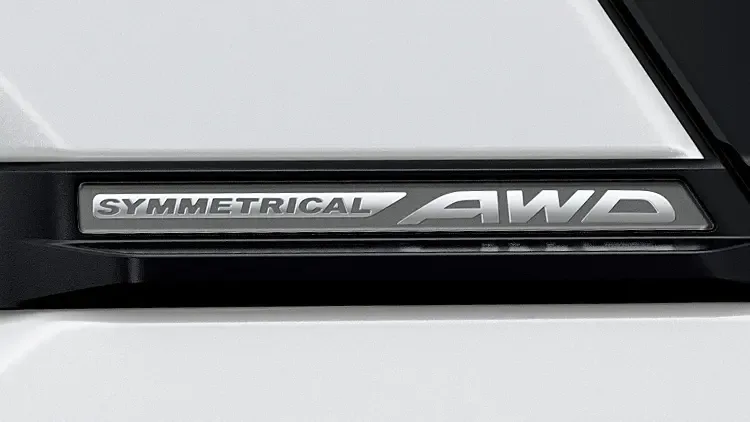 フォレスターの白いボディに付く「SYMMETRICAL AWD」のエンブレムの接写。全車に備わる四輪駆動の表示