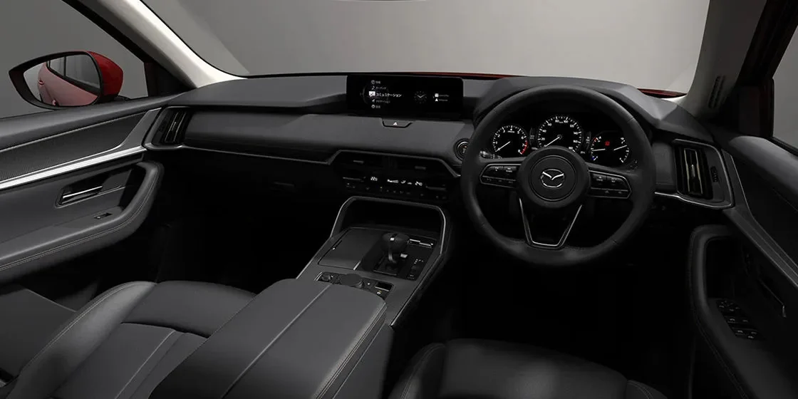 CX-60の黒い内装。ステアリングの先にメーターと中央のディスプレイが並び、センターコンソールにシフトが見える