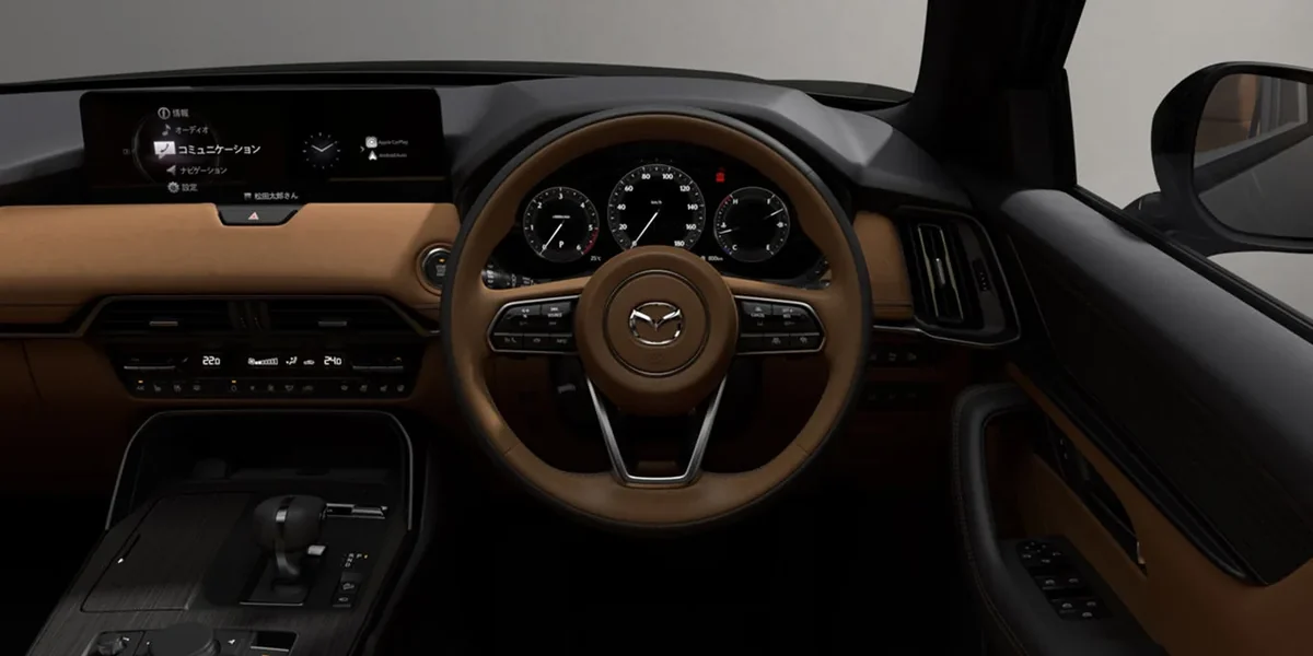 CX-60の運転席まわり。茶色い革のステアリングとダッシュボード、メーターと横長のディスプレイが見える