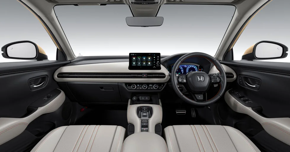 明るいグレーの内装のZR-Vの運転席まわり。右ハンドルの前にメーター、中央にディスプレー、手前に淡い色の前席2つが並ぶ