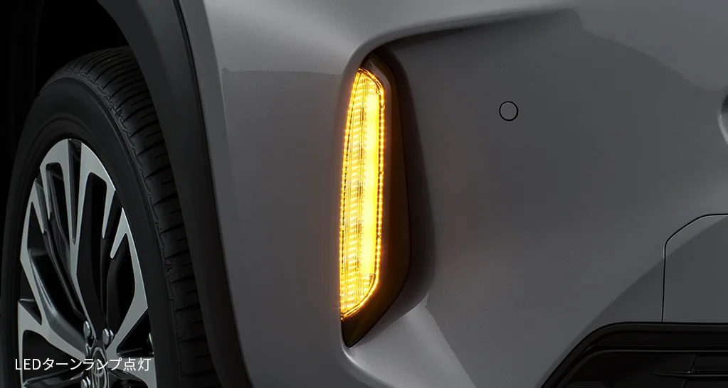 ヤリス クロスのフロントフェンダー付近のアップ。タイヤの前で、LEDのターンランプがオレンジ色に点灯している