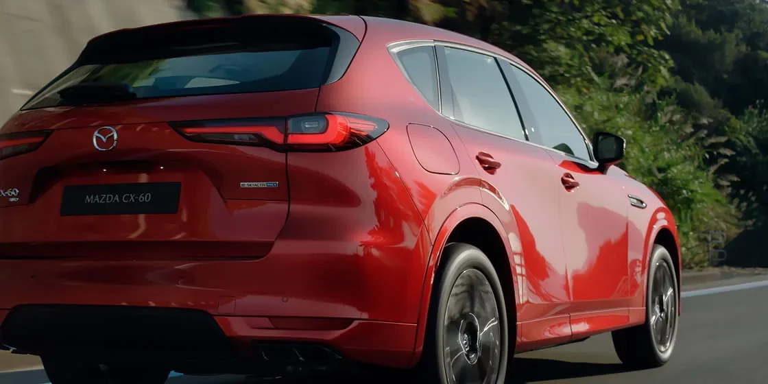 赤いCX-60を斜め後ろから見た外観。横長のテールランプとリアゲート、後ろのホイールが見える