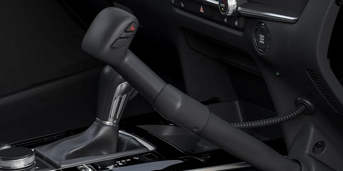 CX-30のシフトレバーとエンジンのスタートボタンのアップ。黒いレバーの奥に、丸いボタンが見える