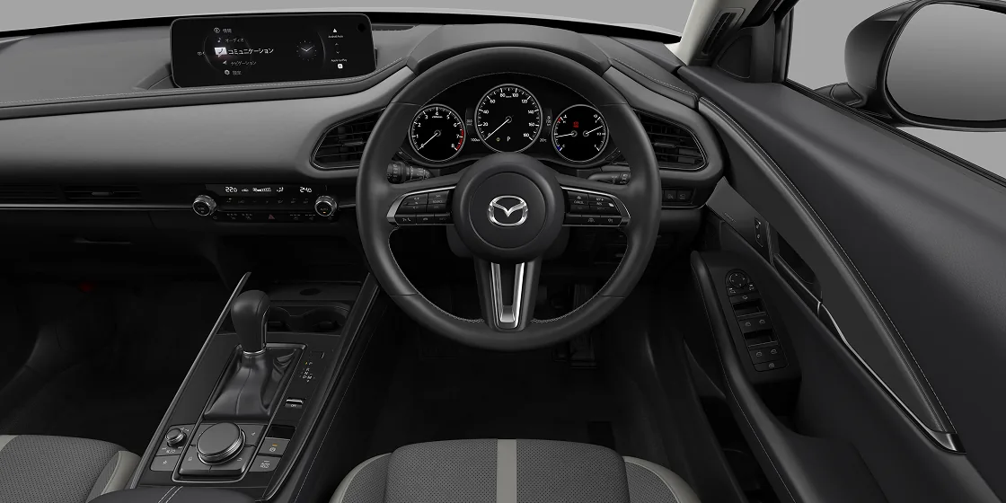 CX-30の運転席を真後ろから見た様子。ハンドルの奥に丸いメーターが3つ並び、ダッシュボードの上に横長の画面がある
