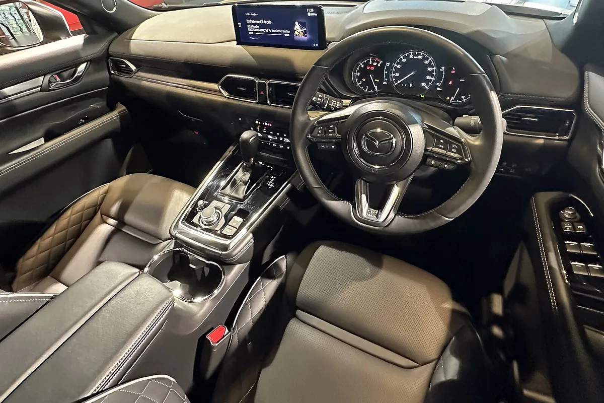 マツダ CX-8（XD Exclusive Mode）の運転席まわり。右ハンドルのステアリングとセンターコンソール、キルティングの革シートが見える