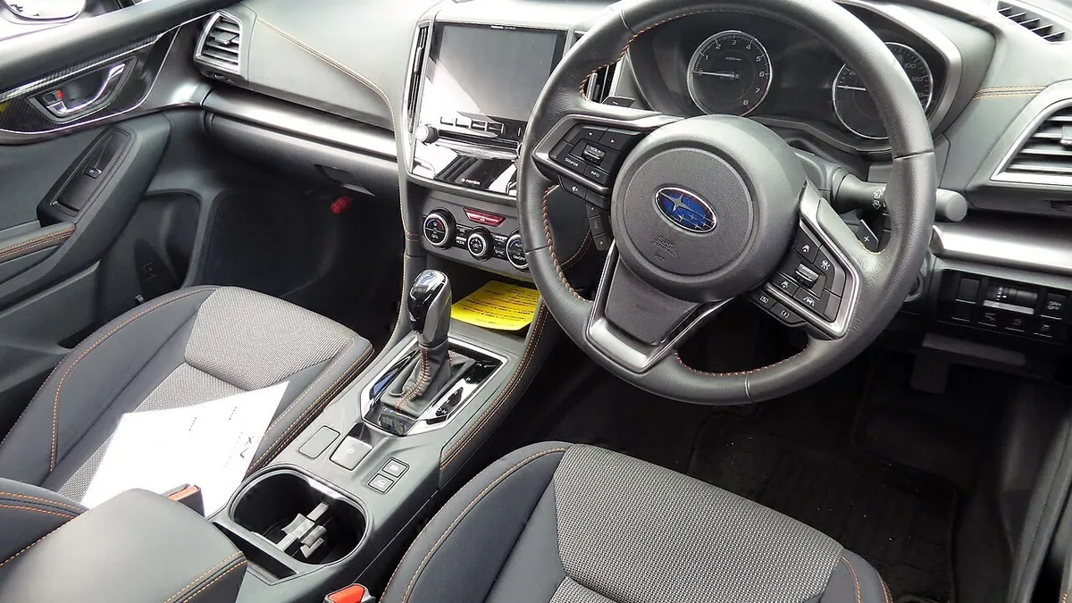 改良前のXV 2.0i-L EyeSightの運転席まわり。右ハンドルで、中央のディスプレイとオレンジのステッチが入ったシートが見える