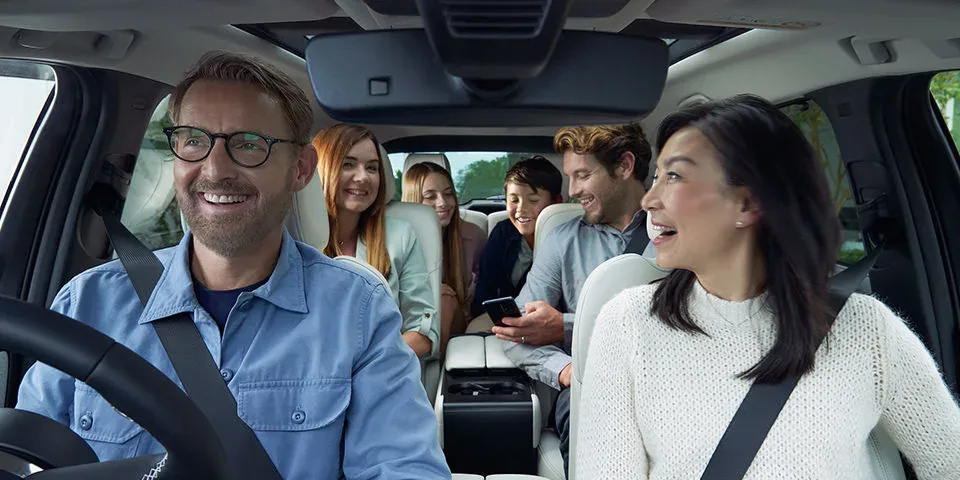 CX-80の車内で、運転する男性と助手席の女性、後ろの席の家族が笑い合っている様子
